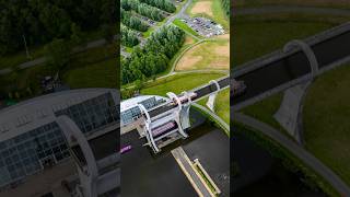 Falkirk Wheel turning with the small Jaggy Thistle boat going down alongside a tour barge canal [upl. by Lauer383]