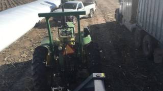 Unloading grain bag JD 4010 remote steer and Loftness grain bag unloader [upl. by Ierna]